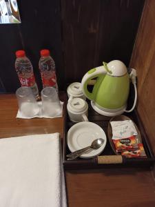 贾蒂卢维巴厘岛狄阿莫酒店的托盘,包括茶壶、盘子和水瓶