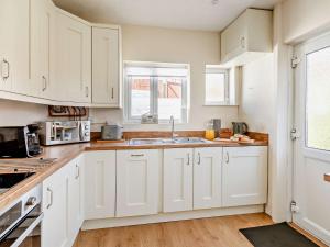 佩恩顿2 Bed in Paignton 92055的厨房配有白色橱柜和水槽