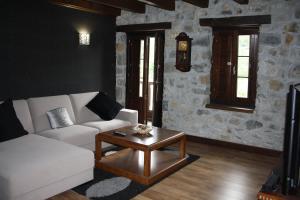CampomanesHotel Rural El Reundu的客厅配有白色沙发和茶几