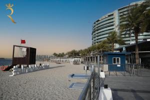 阿布扎比Al Raha Glamour 3BR with Beach Access的拥有建筑和度假胜地的沙滩
