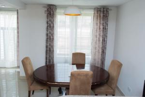 利隆圭Divine Heights Apartments Lilongwe Area 43的一间带木桌和椅子的用餐室