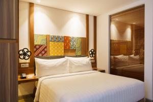 库塔Fairfield by Marriott Bali South Kuta的卧室设有一张白色大床和一扇窗户。