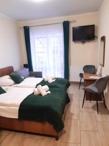 米兹多洛杰库拉布旅馆的一间酒店客房,设有两张床和电视