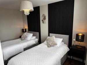 利物浦Stunning two bed city Center apartment的酒店客房设有两张床和吊灯。