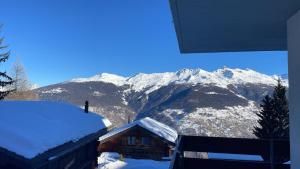 VexEscapade montagnarde idéale !的小屋的背景是带雪盖的山间小屋