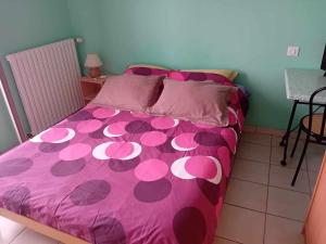 Le BaconLE PETIT VERMONDOIS的一张带粉红色床罩和粉红色波卡圆点的床