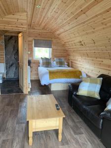 KeltyPond View Pod 2 with Private Hot Tub -Pet Friendly- Fife - Loch Leven - Lomond Hills的小木屋设有两张床和一张沙发