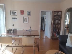 苏黎世Central quiet and cosy apartment near Hallenstadion的客厅配有木桌和椅子