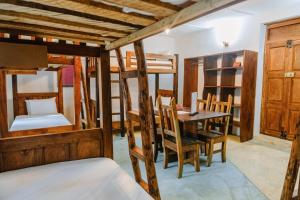 桑给巴尔Shoki Shoki Hostel的客房设有双层床和桌椅。