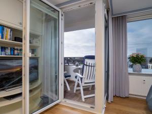 韦斯特兰Appartement Strandnah的客房设有窗户、椅子和书桌。