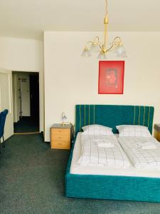 日利纳斯洛文酒店的一间卧室配有一张蓝色床头板的床