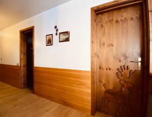 布勒伊-切尔维尼亚Charlotte Lodge Cervinia的一间房间,设有木门,上面涂有鹿