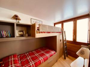 布勒伊-切尔维尼亚Charlotte Lodge Cervinia的一间卧室配有一张带红色毯子的双层床