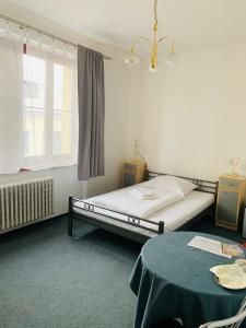 日利纳斯洛文酒店的一间卧室配有一张床、一张桌子和一个窗户。
