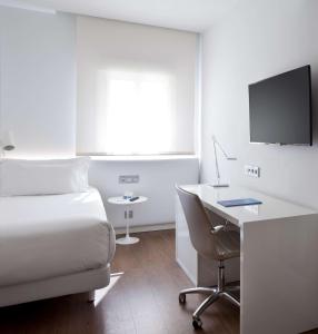 马德里马德里阿托查NH酒店的酒店客房配有一张床和一张带电脑的书桌