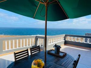 蓬塔杜索尔Residencial Sol Point Art的阳台上的桌子和遮阳伞