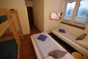 什切尔克Ski House Szczyrk - Czyrna的客房设有三张双层床和一扇窗户。