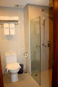 长滩岛Paradise Garden Hotel and Convention Boracay Powered by ASTON的浴室设有卫生间和带毛巾的淋浴。