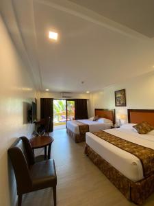 长滩岛Paradise Garden Hotel and Convention Boracay Powered by ASTON的酒店客房配有两张床和一张书桌