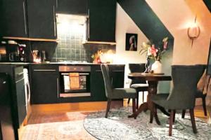 伦敦The Maple Retreat - Hampstead的厨房配有绿色橱柜和桌椅