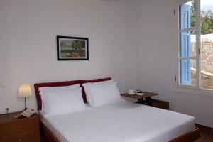 波罗斯Panoramic View apartment的一间卧室配有一张带白色床单的床和一扇窗户。
