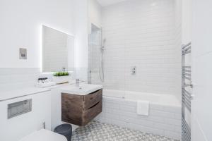 SurbitonRoomspace Serviced Apartments Newlands House的白色的浴室设有水槽和浴缸。
