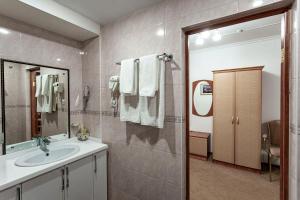 乌拉尔斯克Kurmet Hotel的一间带水槽和镜子的浴室