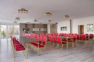 别尔斯克-比亚拉B&B Widok的一间会议室,配有桌子和红色椅子