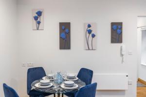 伦敦Iconic London Apartment的一间带桌子和蓝色椅子的用餐室