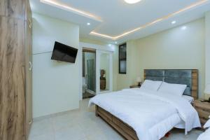 基加利Ibi Villa Retreat的卧室配有一张白色大床和电视。