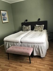 舍夫德Vandrarhemmet Östergatan的一间卧室配有一张带粉红色凳子的大床