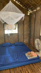 Ban Bok Faiสวนบุศรา ลานกางเต็นท์วิถีเกษตร的配有蚊帐的客房内的一张床位