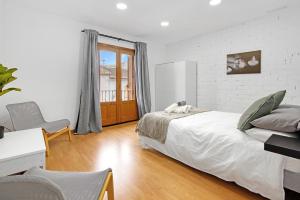 德尼亚Ca L'oliera的白色的卧室,配有床和白色砖墙