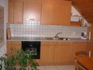 布格多夫Bauernhof Bättwil - b48307的厨房配有木制橱柜、水槽和洗碗机。