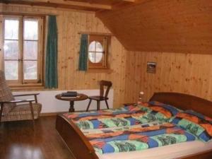 布格多夫Bauernhof Bättwil - b48307的木制客房内的一间卧室,配有一张床