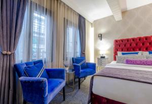 伊斯坦布尔In Pera Boutique Hotel的酒店客房,配有床和蓝色椅子