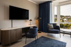 桑讷菲尤尔斯堪迪克公园桑德峡谷酒店的客房设有一张桌子、一台电视和两把椅子