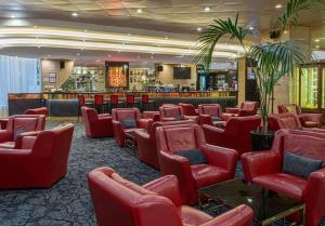 莫斯科雷迪森酒店的一间设有红色椅子的等候室和一间酒吧