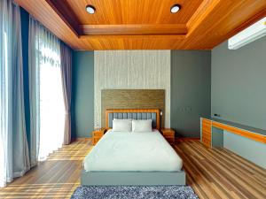 普吉镇Villa Menara Bang Tao的一间卧室设有一张带木制天花板的大床