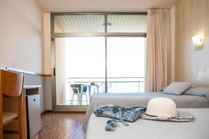 拉梅特拉·德·玛尔RVHotels Hotel Ametlla Mar的酒店客房,配有两张床,床上有一顶帽子