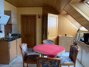 霍恩巴赫伽斯特翰斯莫妮卡酒店的厨房配有粉红色的桌子和椅子
