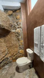 埃拉Rock n Fall Nature Resort的石质浴室设有卫生间和毛巾。