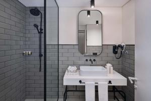 迪拜The Manor By JA的浴室配有白色水槽和淋浴。