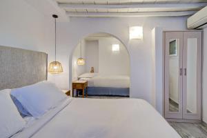 米克诺斯城Hotel Madalena的一间白色卧室,配有两张床和镜子