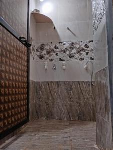 戴维格Om Laxmi Narayan Homestay的带淋浴的浴室(带石墙)