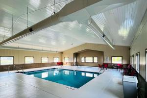 威斯康星戴尔Sleep Inn & Suites Lake Delton-Wisconsin Dells Newly Renovated 2024的一座大型游泳池,位于一座配有红色椅子的建筑内
