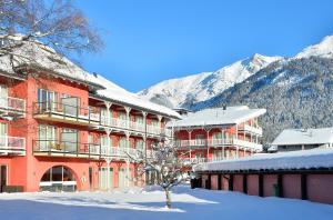 蒂罗尔-泽费尔德Das Hotel Eden - Das Aktiv- & Wohlfühlhotel in Tirol auf 1200m Höhe的雪中建筑物,前面有一棵树