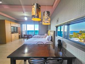 西归浦市OROJEJU的一间卧室设有一张床铺和一张桌子,享有海景