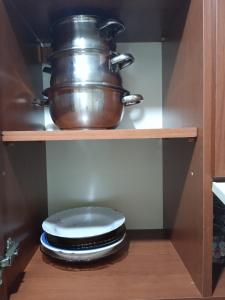 伊斯坦布尔Hisar Apartments的厨房里的碗架上的锅和盘子
