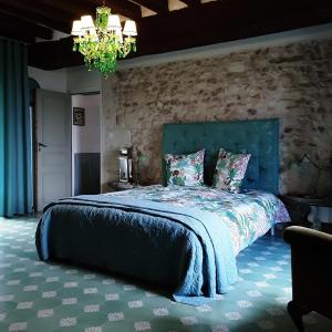 Châteauvieux'La Ménagerie'的一间卧室设有一张带石墙的大床